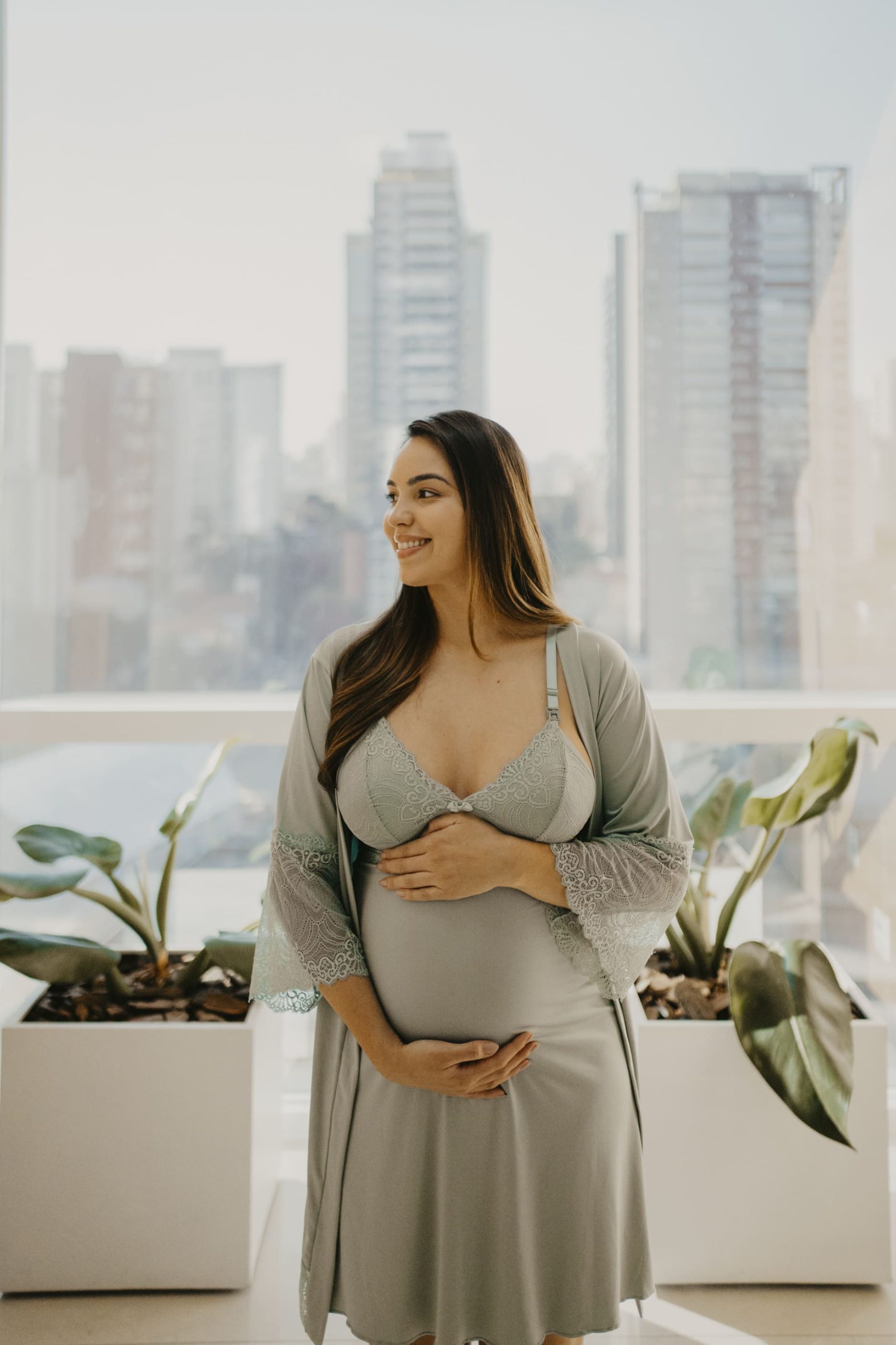 Gravida em um vestido cinza olhando para o lado